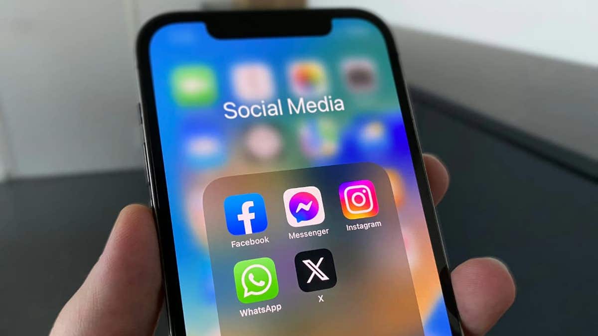 Smartphone screen showing popular social media apps including Facebook, Instagram, WhatsApp, and X.