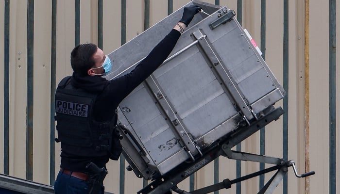 Police and forensic teams inspect a crane and a window believed to have been used in what the French Interior Ministry said was a robbery at the Louvre museum during which jewellery was stolen, as pedestrians pass nearby, in Paris, France, October 19, 2025. — Reuters