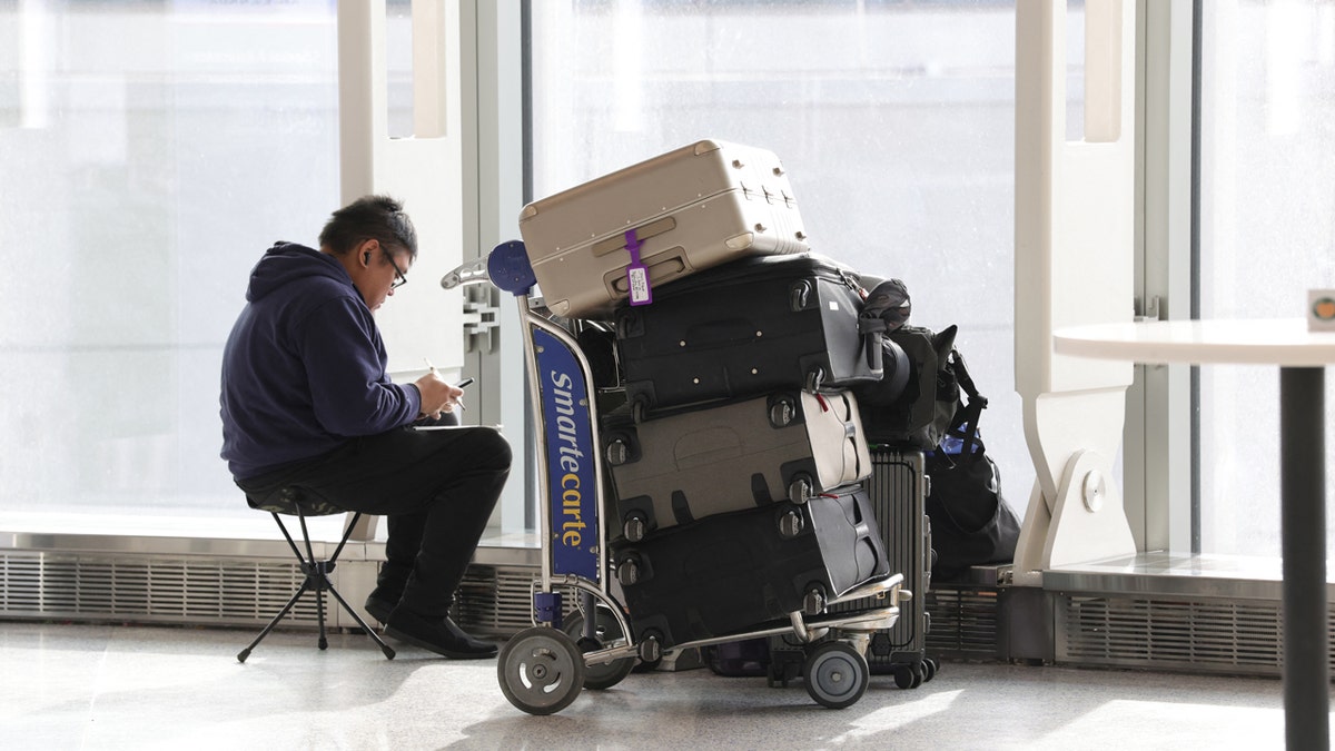 A man waits with his luggage